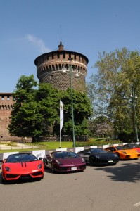 A row of multi-coloured Lamborghinis next to the Castello Sforzesco.