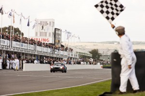 Formula 1 test driver Giedo van der Garde and David Hart cross the finish line in the latter AC Cobra during the RAC TT Celebration race at the 2014 Goodwood Revival.