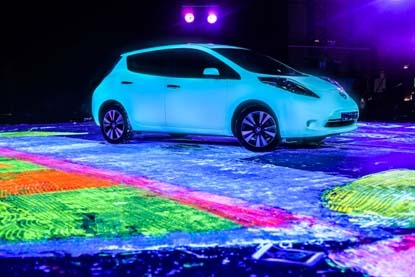 Artist Ian Cook used the tires of the Nissan LEAF to drive glow-in-the-dark paint across the surface of the canvas 