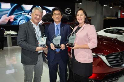 Masaharu Kondo, President, Mazda Canada, accepts three AJAC awards from Mark Richardson, AJAC President (left) and Stephanie Wallcraft, AJAC Vice-President (right) (CNW Group/Mazda Canada Inc.)